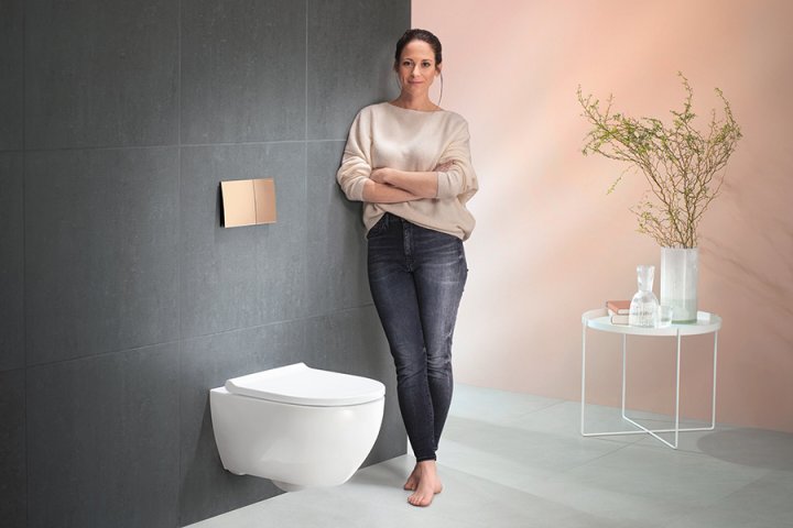 Frau neben an Schiefer-Wand montiertem WC
