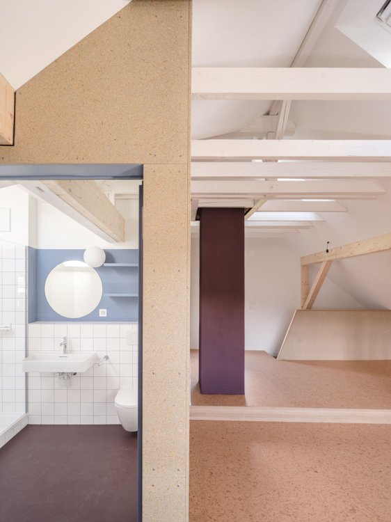 Blick in modernes Bad sowie in Dachgeschoss mit alten Balken