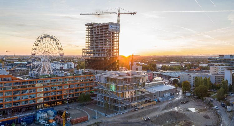 «WERK 12» in München von MVRDV und N-V-O Nuyken Von Oefele Architketen bei Sonnenuntergang mit München im Hintergrund.