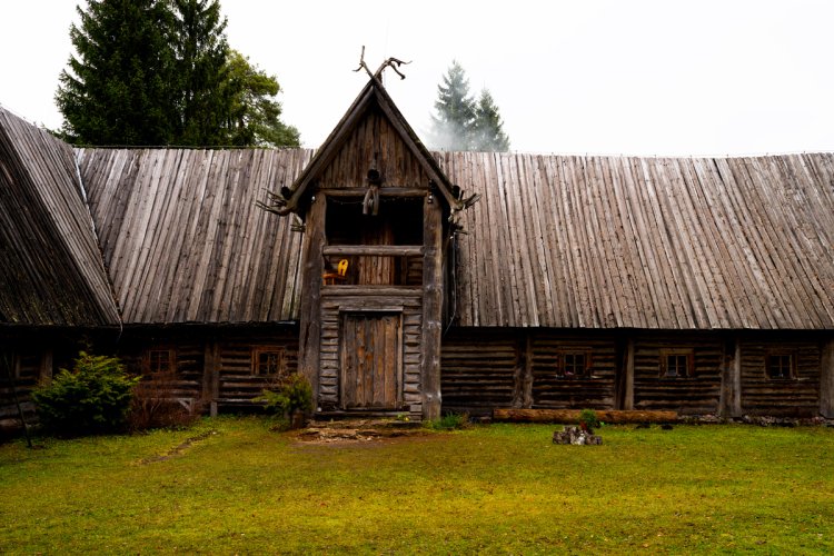 Ein hölzernes Riegenhaus in Estland auf grüner Wiese