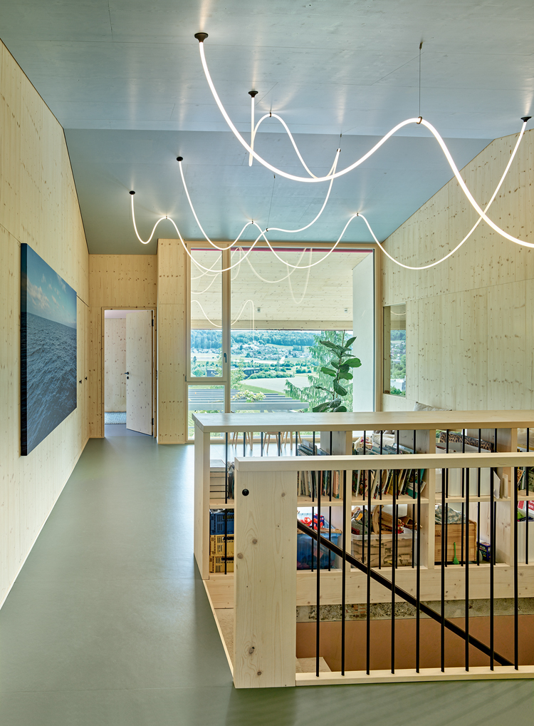 Innenraum eines Hauses mit viel Holz und einer Lichtschnur an der Decke