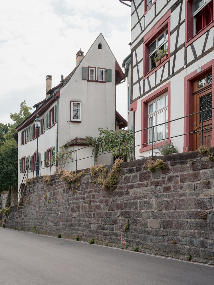 ein schmales altes Haus oberhalb einer Mauer