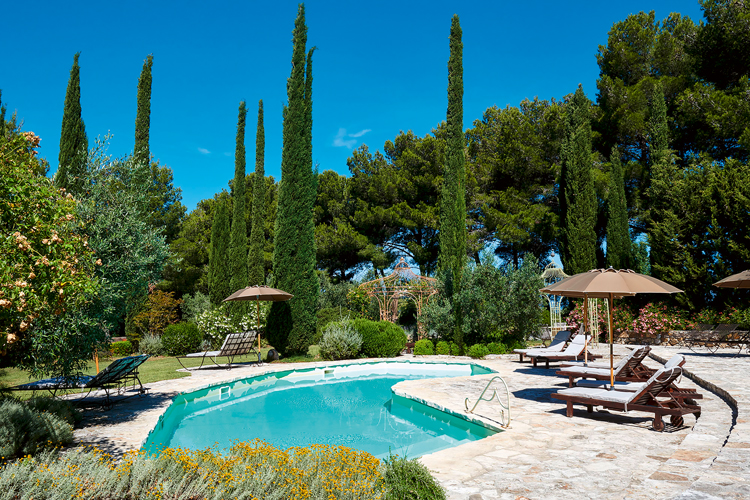 Pool mit Liegestühlen von Poggio ai Santi mitten in der Natur.