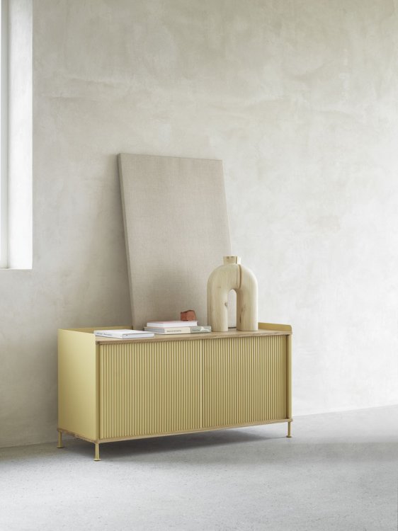 Pastellgelbes Sideboard aus Holz mit geraffter Front.