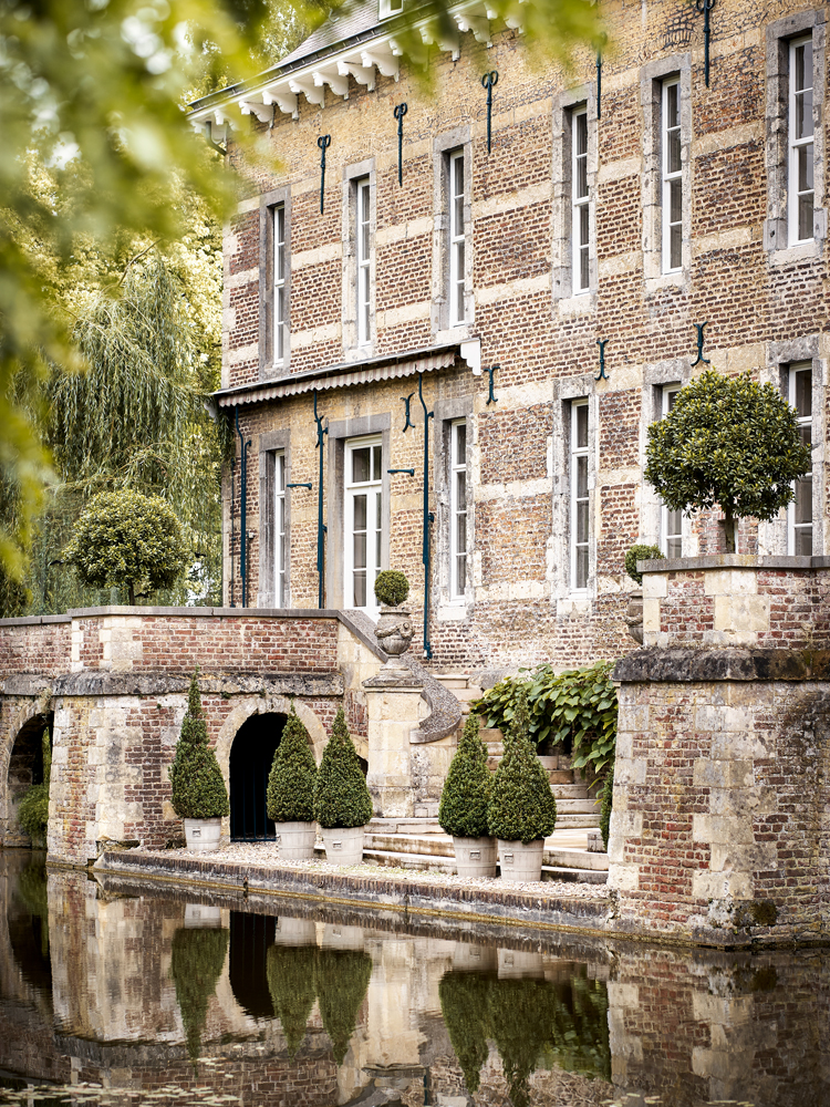 Blick auf Schlossfassade it Wassergraben im Vordergrund.