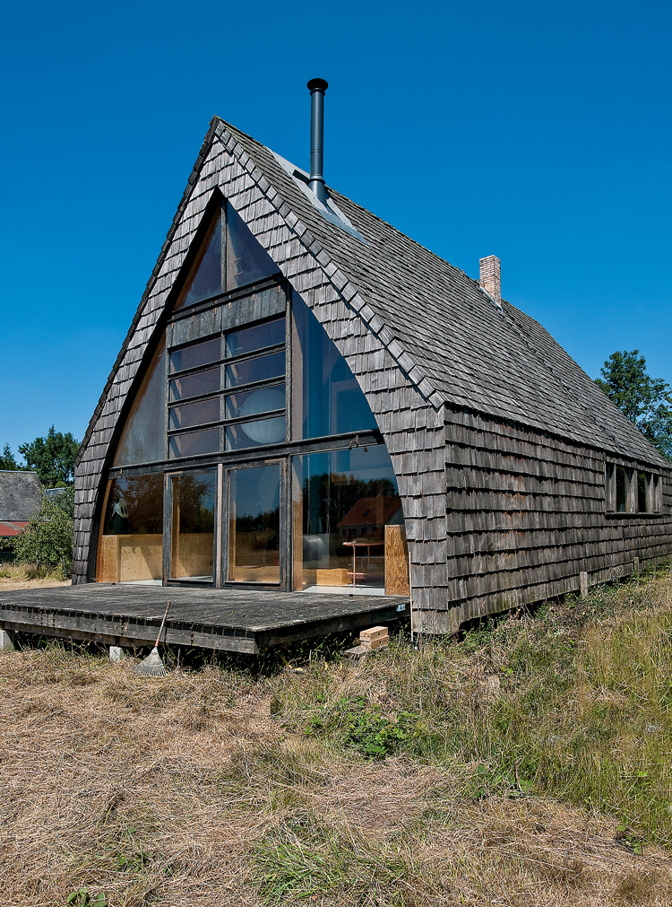 Holzhaus von aussen mitten im Grünen mit Holzfassade.