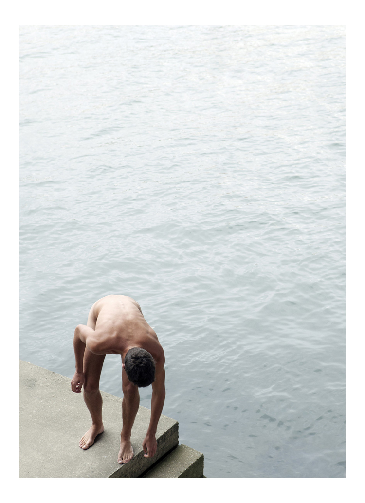 Farbfotografie von einem Mann der über eine Betontreppe aus dem Wasser steigt.