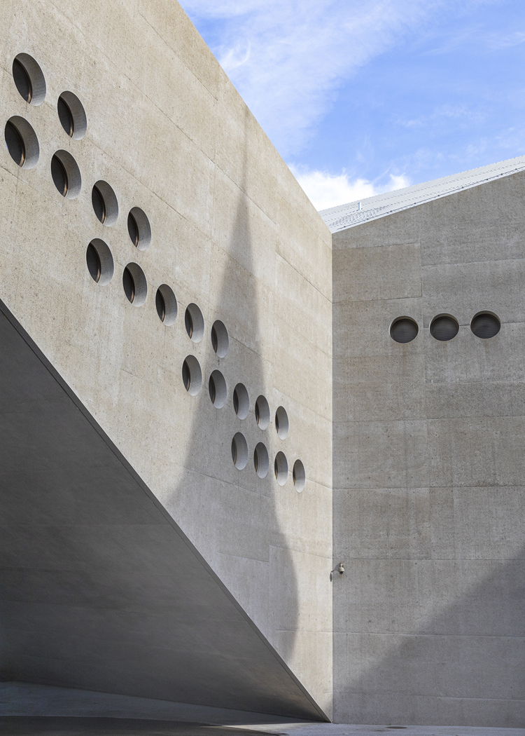 Detailansicht Betonbau mit runden Fenstern.