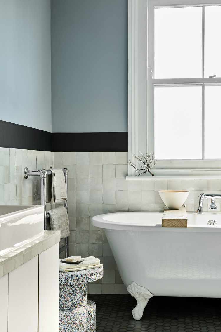 Badezimmer mit blauer Wand und weisser freistehender Wanne.