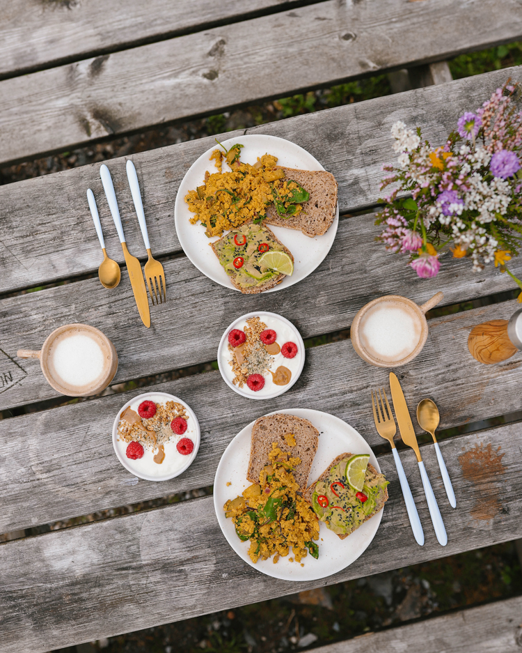 Von oben fotografierter Tisch mit frisch zubereitetem Essen für zwei.