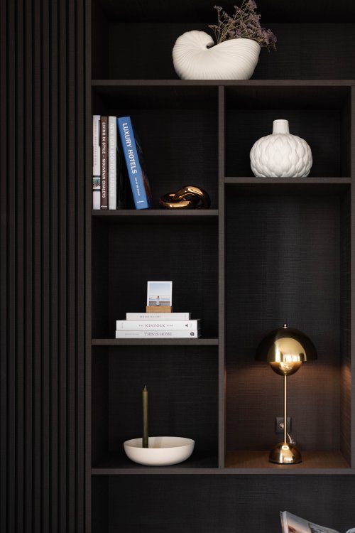 Schwarzes Regal mit verschiedenen Wohnaccessoires und Bücher