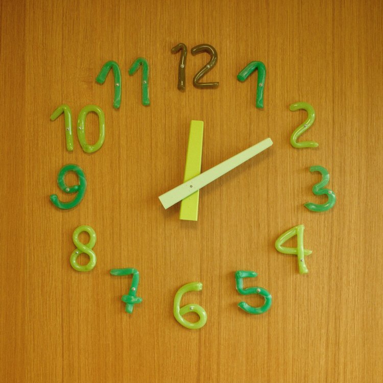 Detailansicht der ISSU ISSU Uhr mit handschriftlichen Ziffern aus mundgeblasenem Glas in Jahreszeitenfarben.