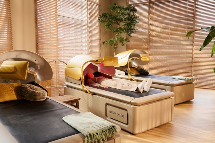 Person liegt in einem goldenen Hydro-Massagebett in einem warm beleuchteten Raum der Mind Oasis.