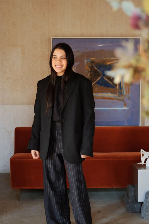 Porträt von Gründerin von Basalto Collective Paulina Resendiz in einem schwarzen Hosenanzug.