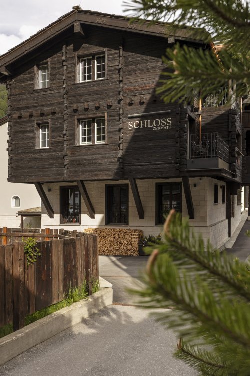 Aussenansicht des Hotels Schloss Zermatt in einem traditionellen Holzchalet.