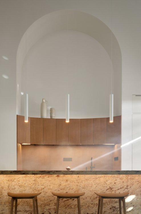 Halbrunder Küchenraum mit Theke im Vordergrund. Die Architektur erinnert an eine Kirche.