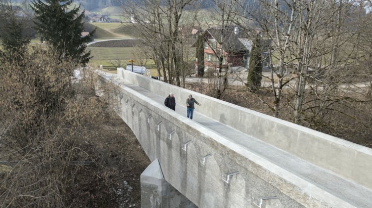 Zwei Passanten überqueren eine Fussgängerbrücke.