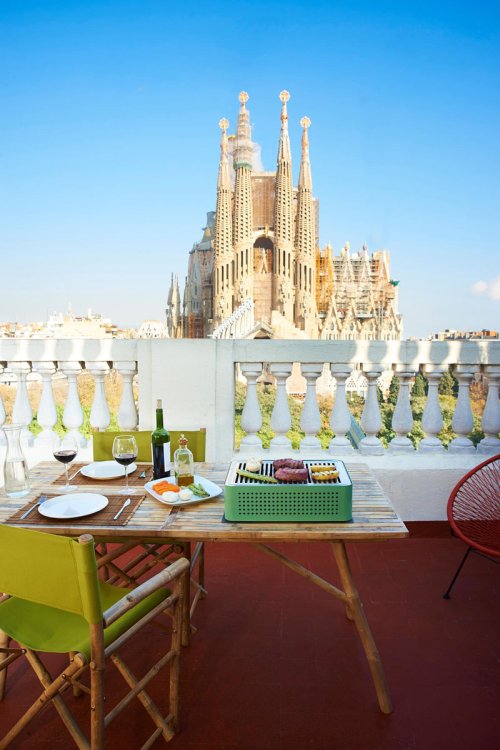 Transportabler Outdoor-Grill «Mon Oncle» auf einem Balkon mit Aussicht auf eine Kirche.