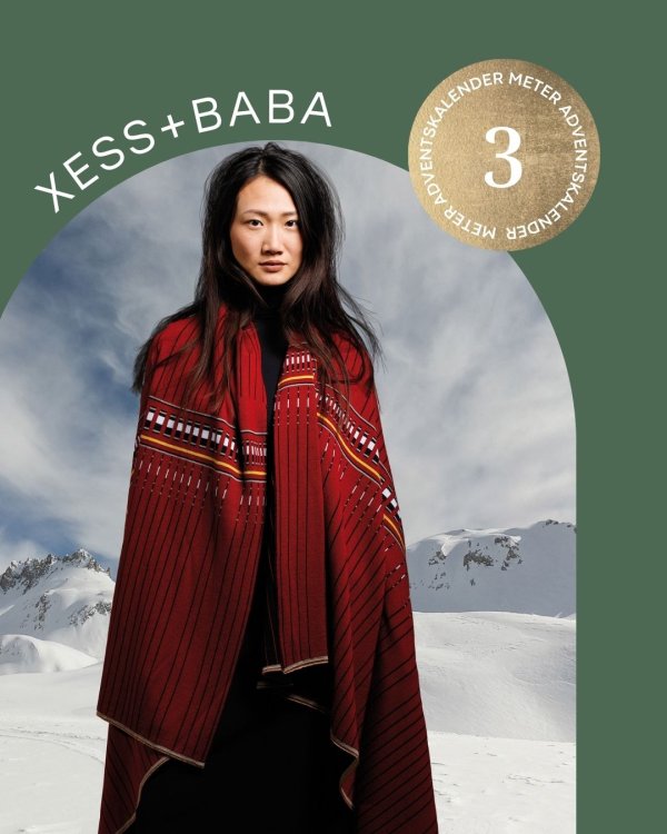 Frau in Decke gehüllt vor Bergkulisse