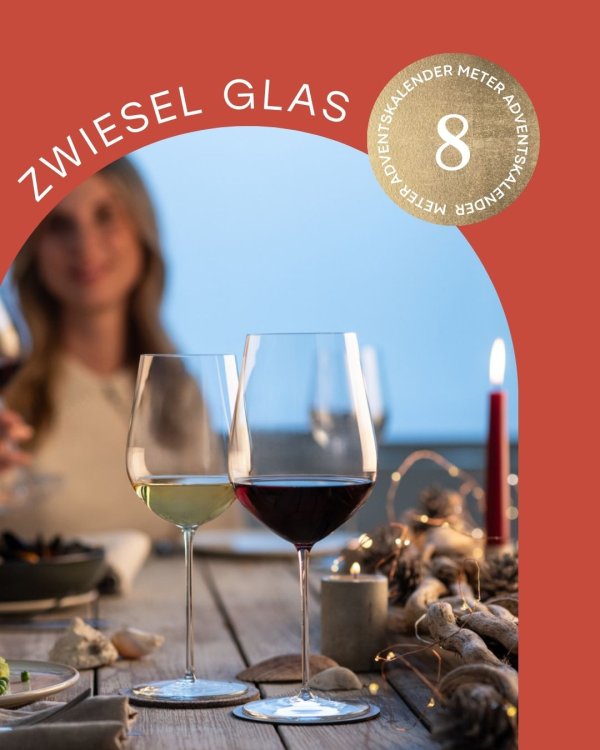 Esstisch mit Weingläsern und Frau im Hintergrund