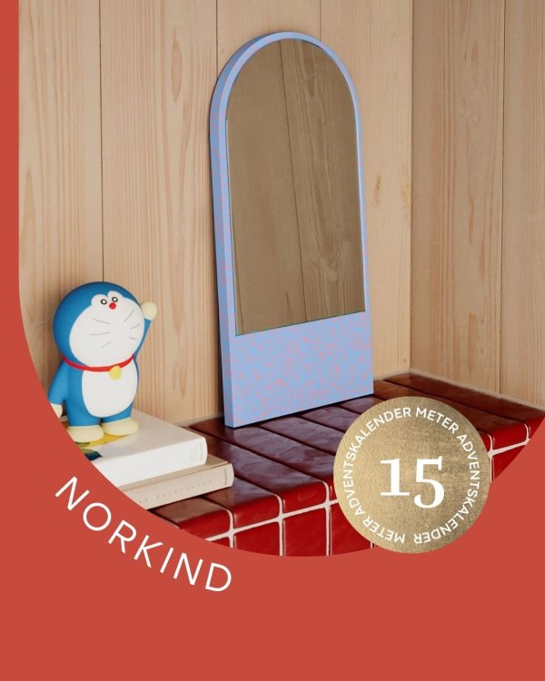 Spiegel und Bücherstapel auf Wandvorsprung